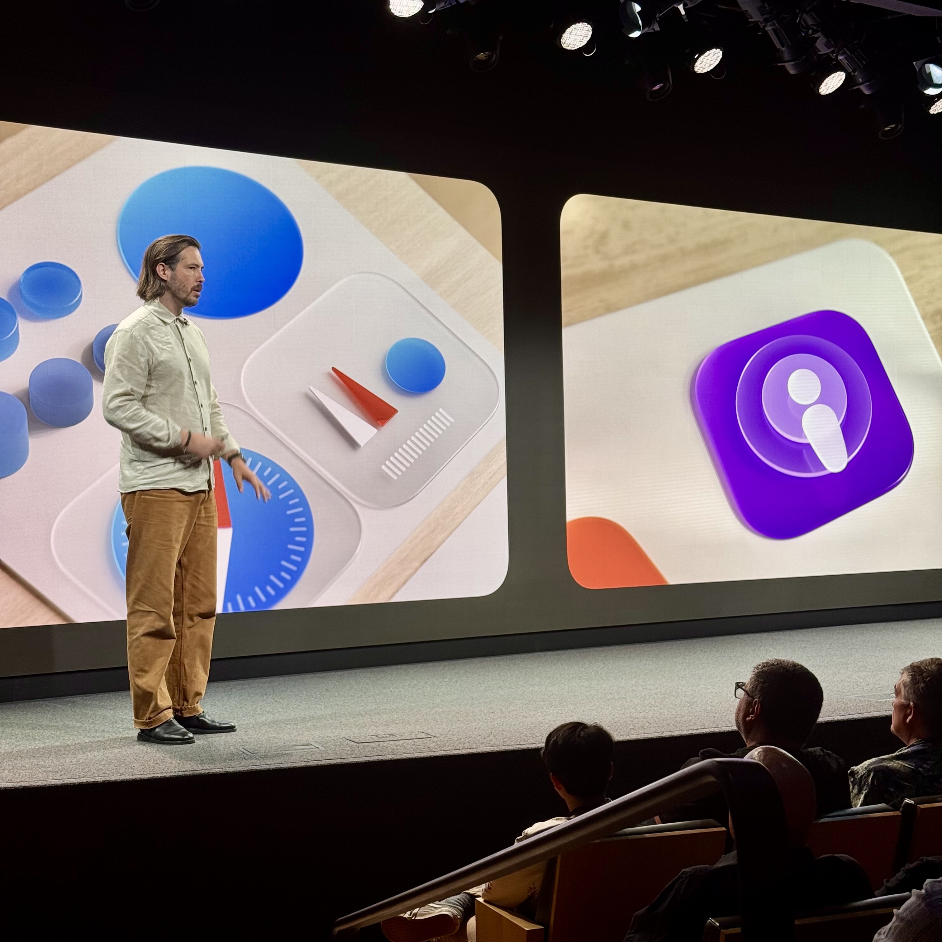 Apple developer standing in front of a presentation about the latest design update on Apple softwares